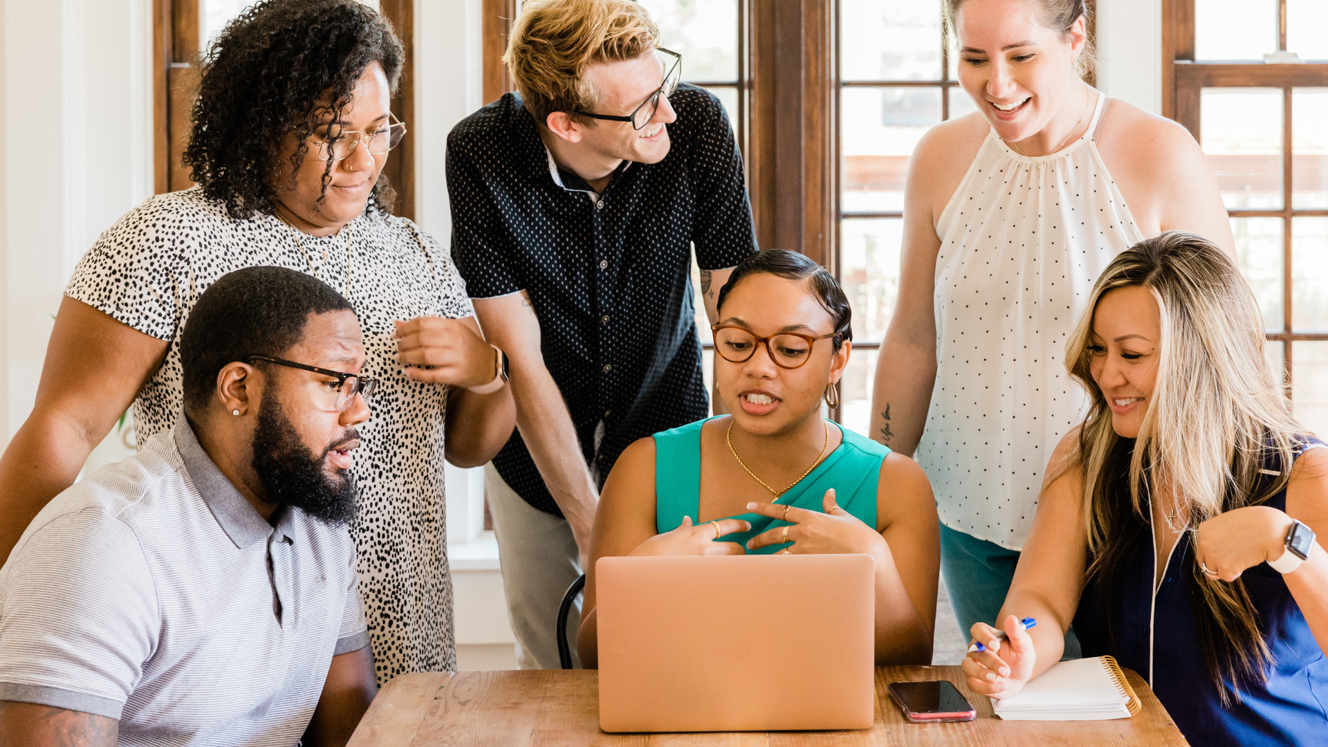 A team huddled around a laptop