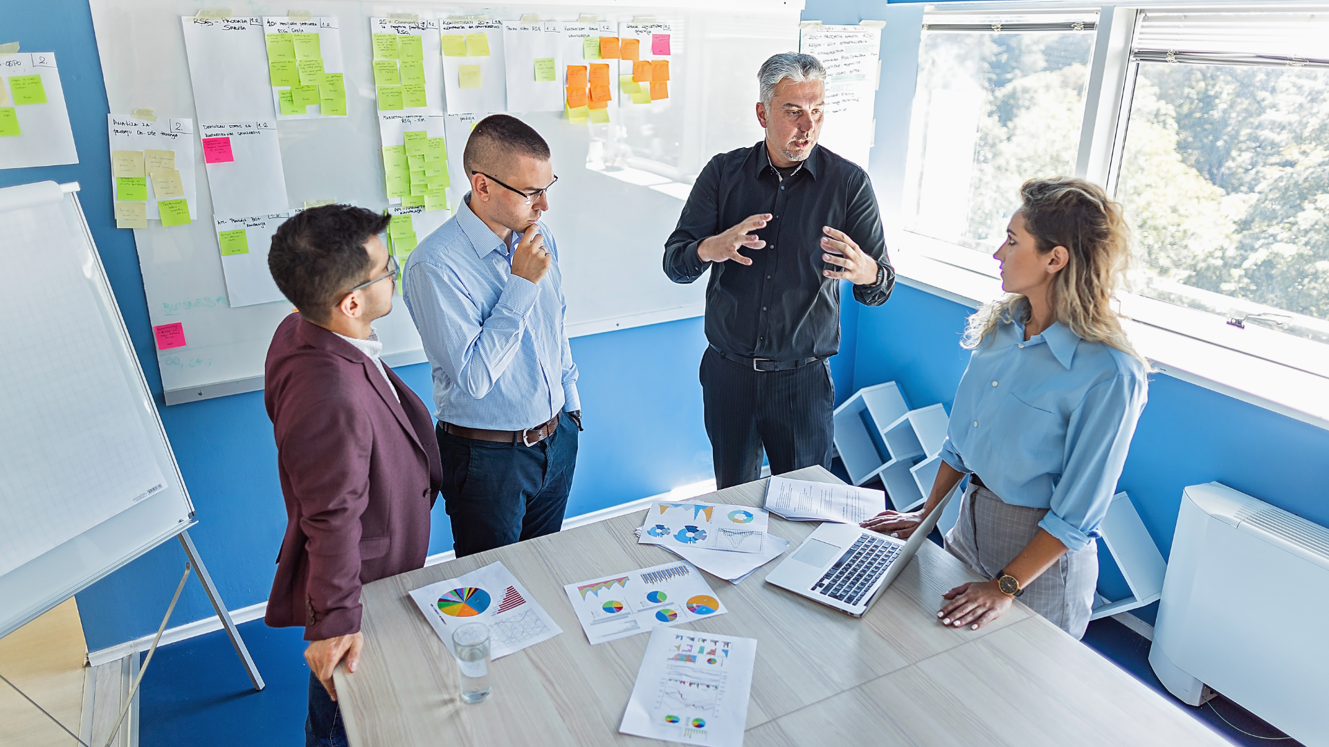 A team stands in front of a whiteboard