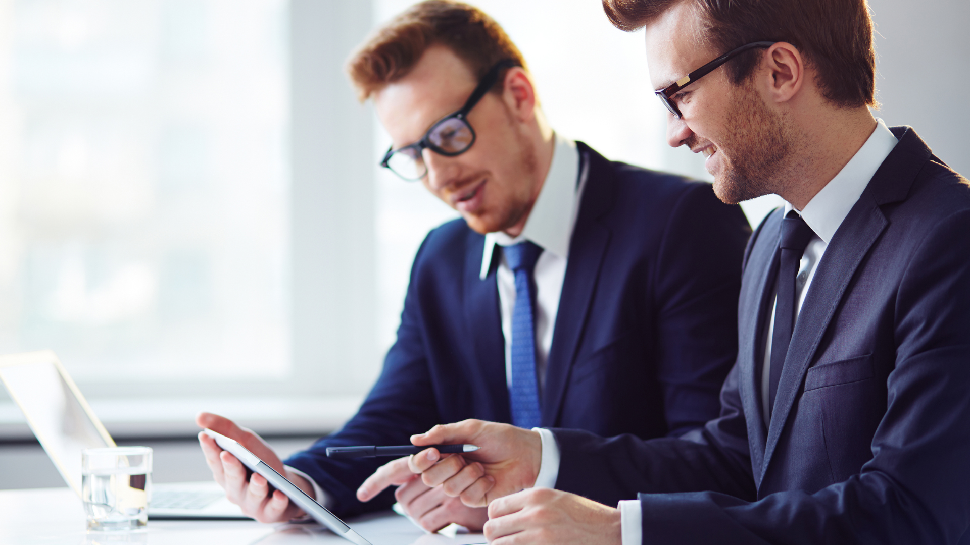Two businessmen looking at a device