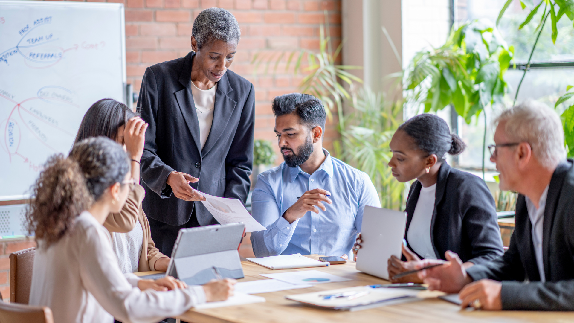 A business woman presents a document to her team